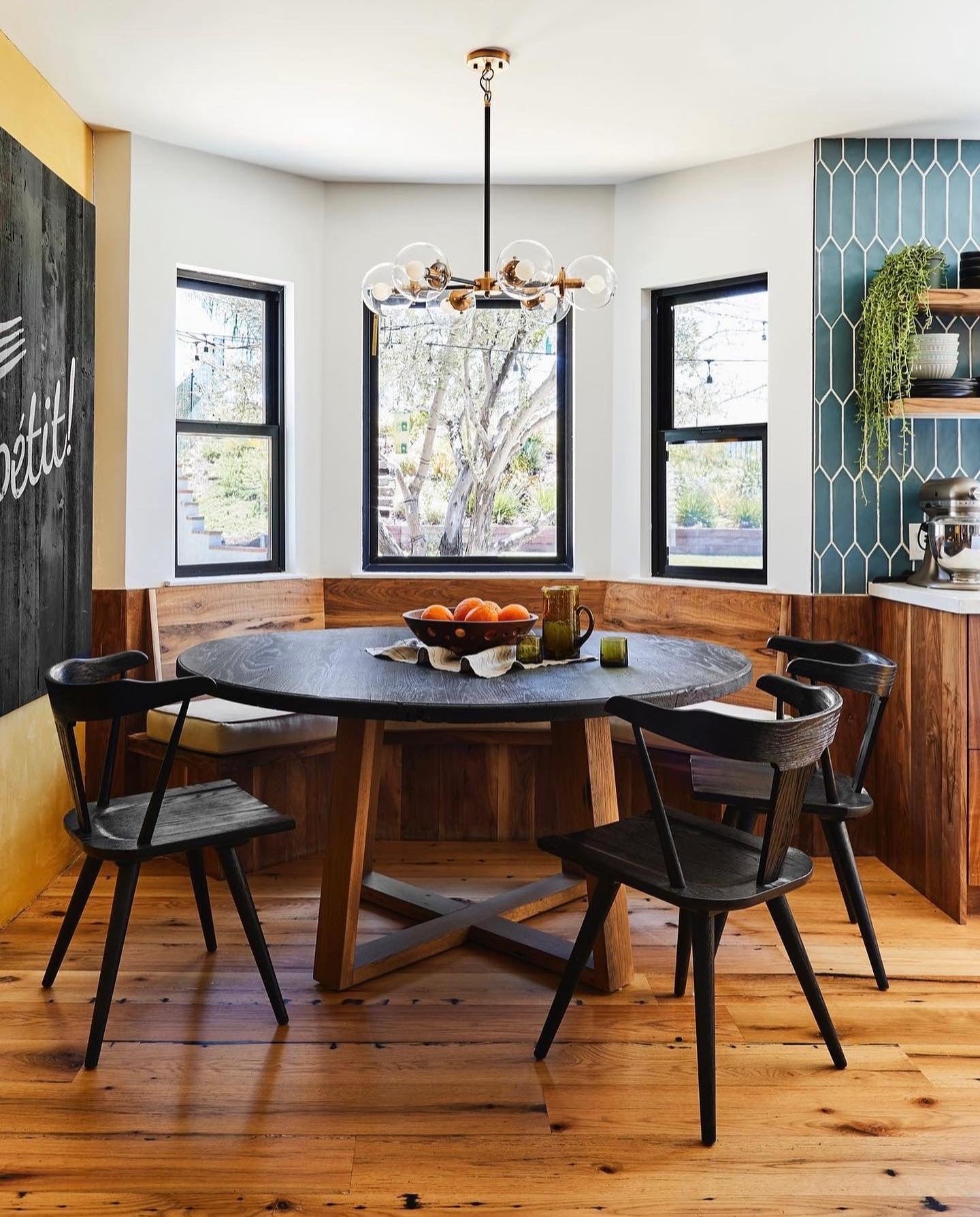 Round table with black wooden top and natural colored oak legs in "X" shape