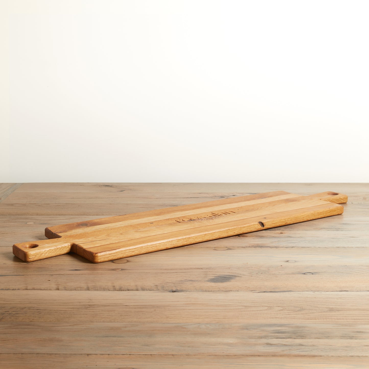 Long rectangle charcuterie board with handle on both ends. Relclaimed oak with natural color and wood grains.