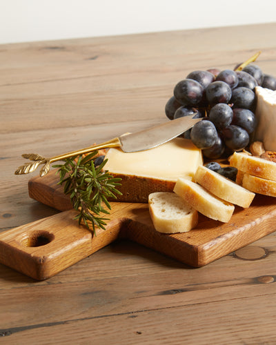 Reclaimed oak charcuterie board with handle, natural color. Shown with fruits and cheeses