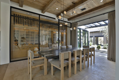Dining room with glass enclosed wine cellar. Beams, t&g on ceiling. Open to outside