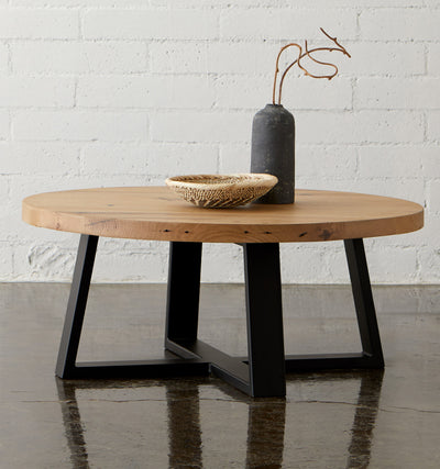 The ox coffee table with white oak top and black metal base, propped