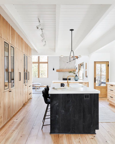Kitchen with Reclaimed beechwood wall cabinets with natural wood grain. Reclaimed oak flooring, with black wood island and white countertop